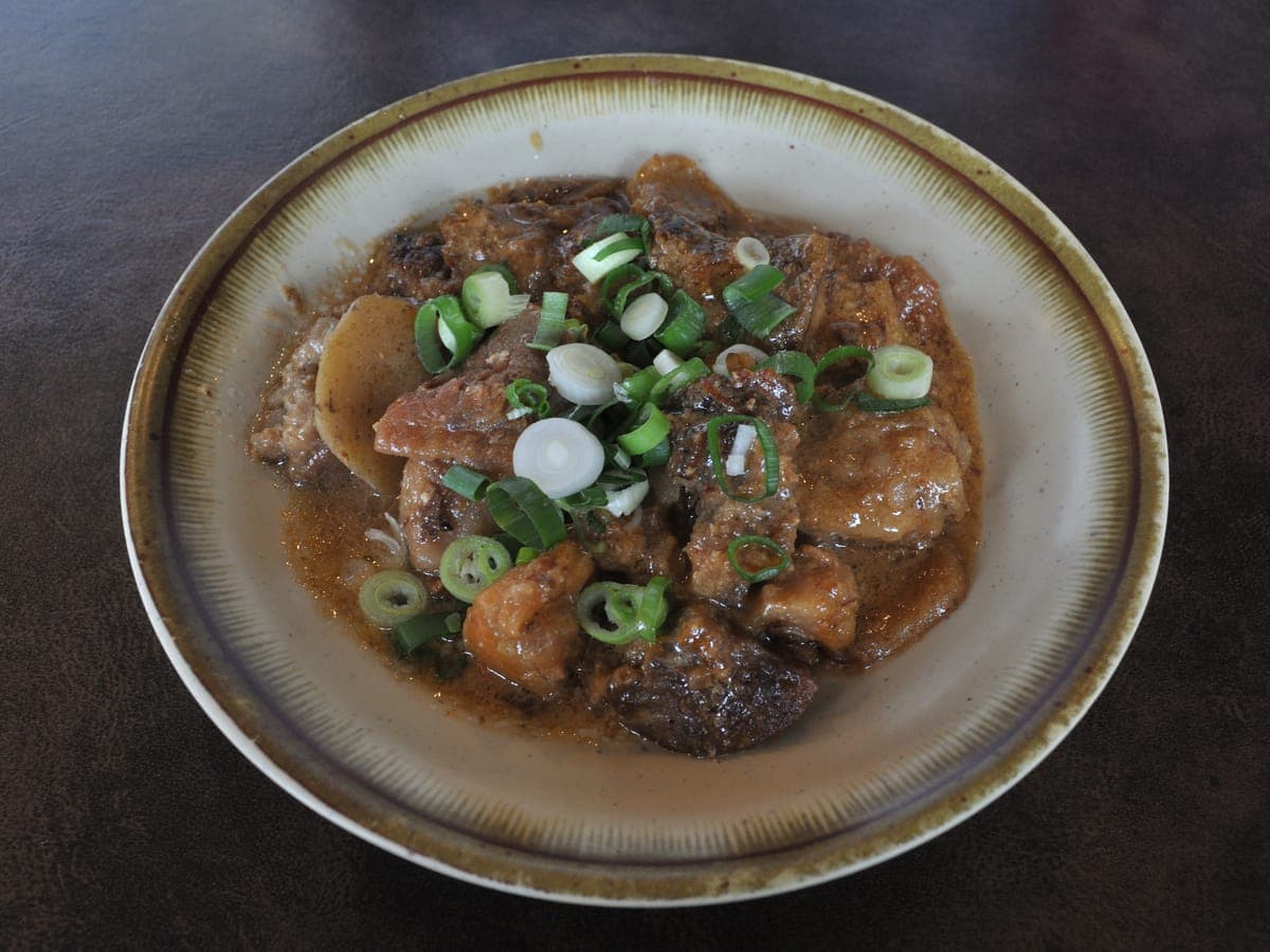 Doteyaki, stewed in miso, in a bowl topped with green onion