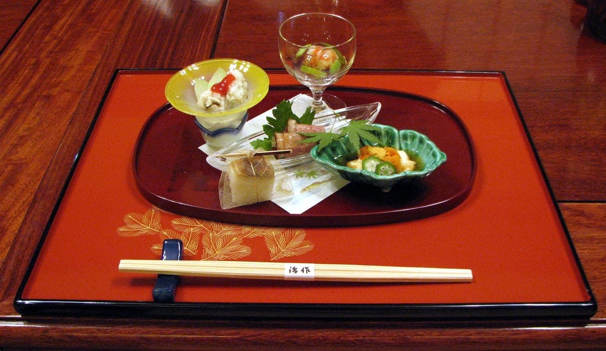 A kaiseki starter of several small dishes on a lacquered tray