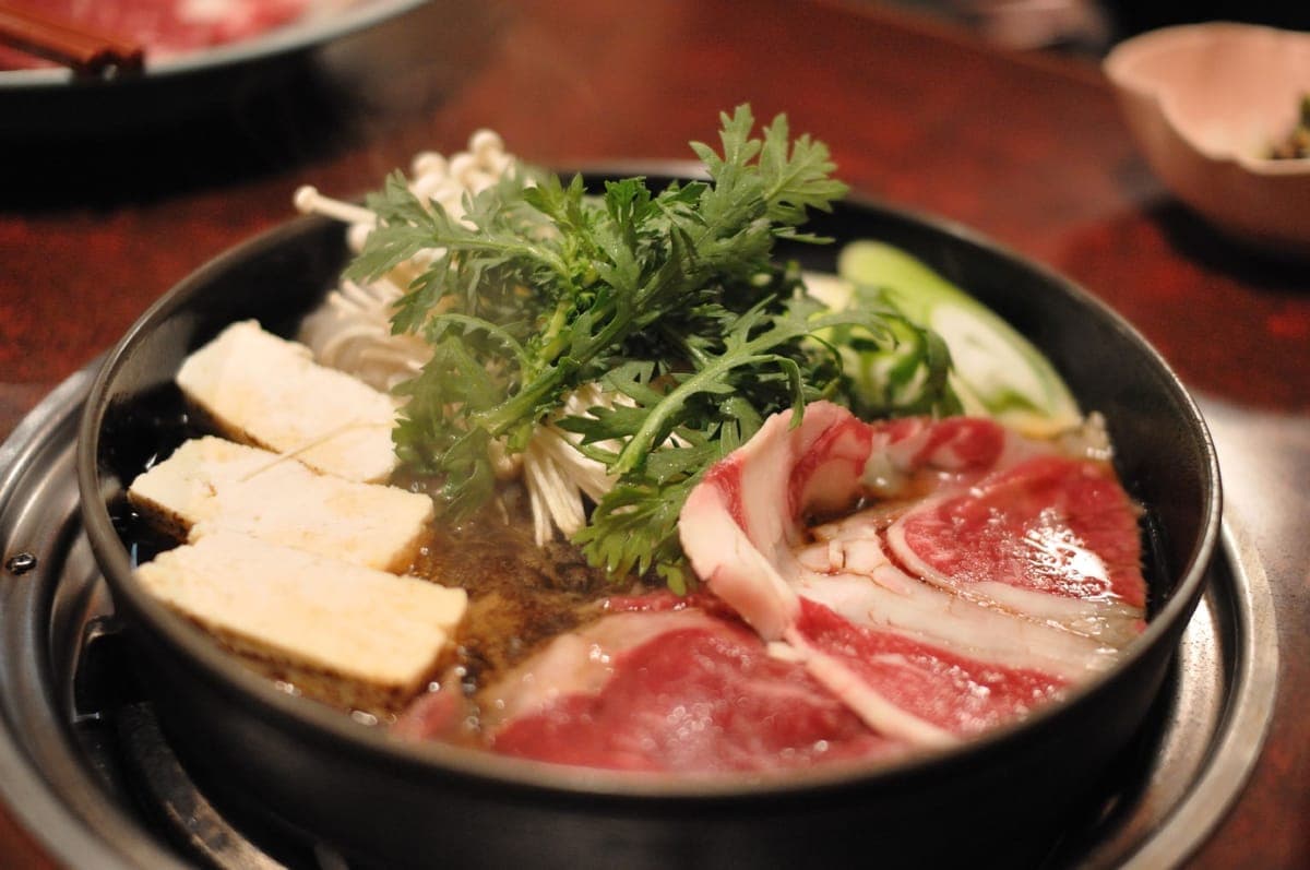 Sukiyaki: beef, tofu and vegetables in a shallow iron pot