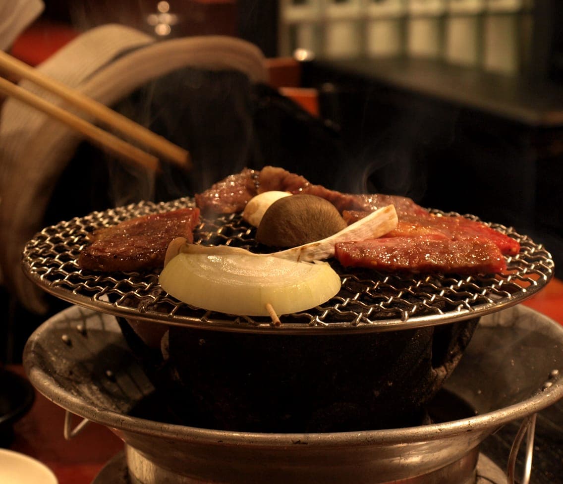 Meat grilling on a tabletop charcoal grill