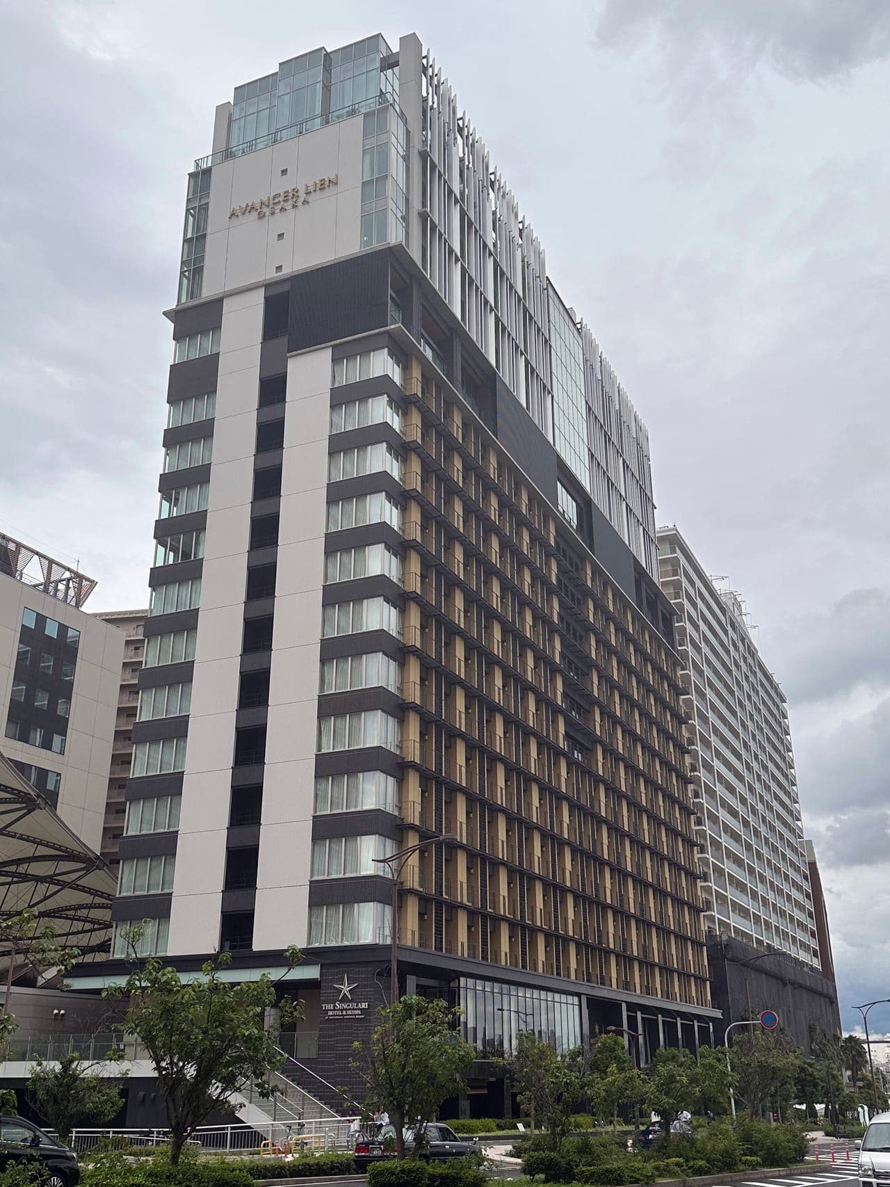 Exterior of The Singulari Hotel, with the hotel sign at street level
